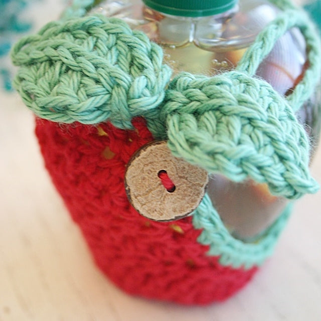 Red apple cozy for apple shaped soap dispenser with wooden button, crocheted by Susan Carlson of Felted Button | Colorful Crochet Patterns