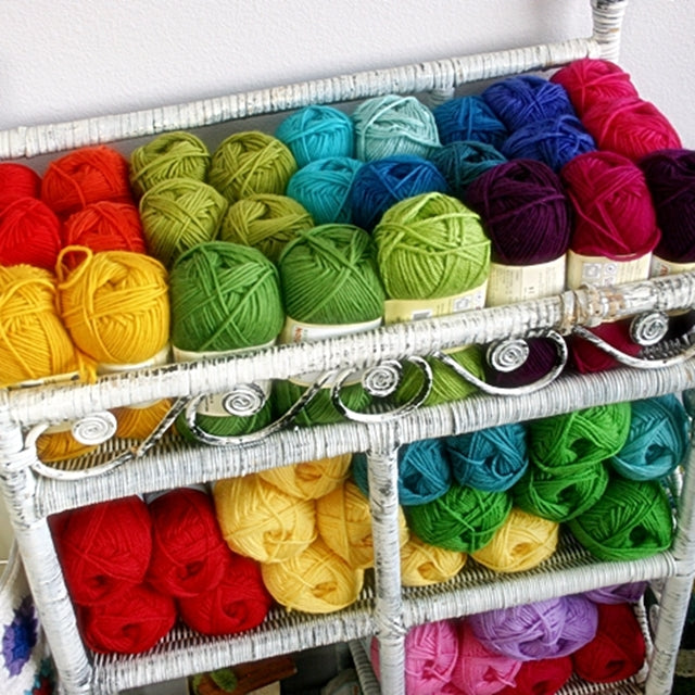 Rainbow of colorful yarn in wicker shelf, Susan Carlson of Felted Button | Colorful Crochet Patterns