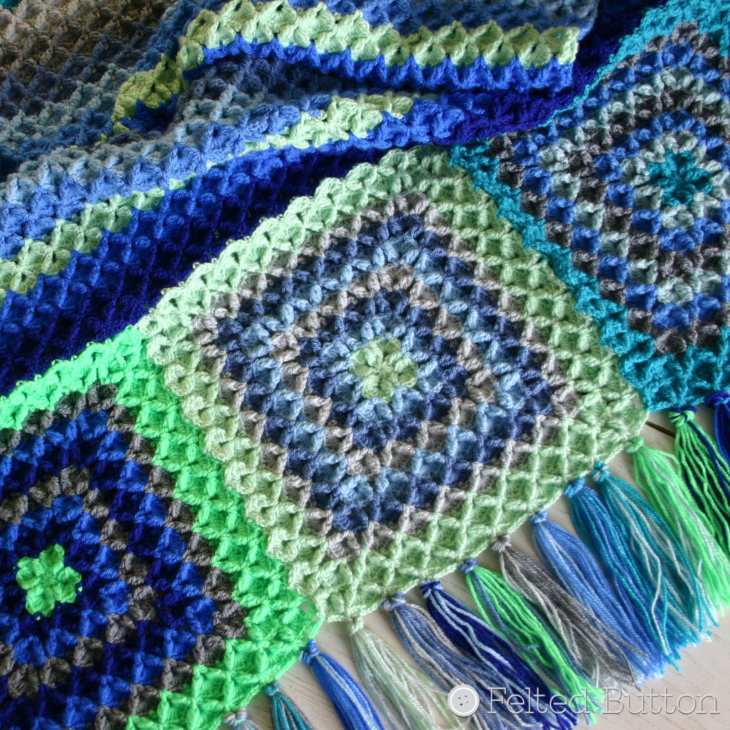 Blues, greens and grey highly textured crochet blanket with fringe, Parrotlet's Flight Blanket crochet pattern by Susan Carlson of Felted Button