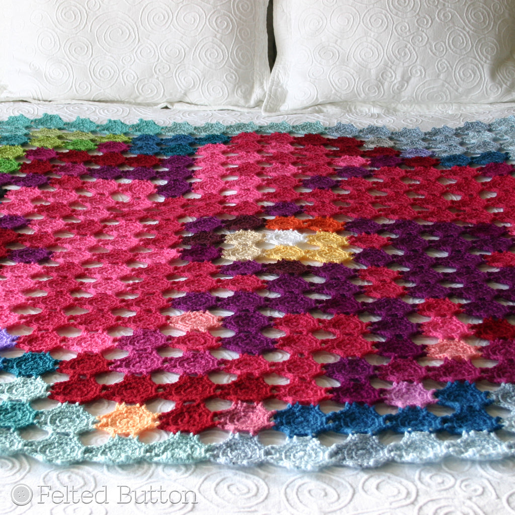 Crochet blanket made with motifs that make picture of a flower, Pointillism Posie Blanket crochet throw or afghan pattern by Susan Carlson of Felted Button