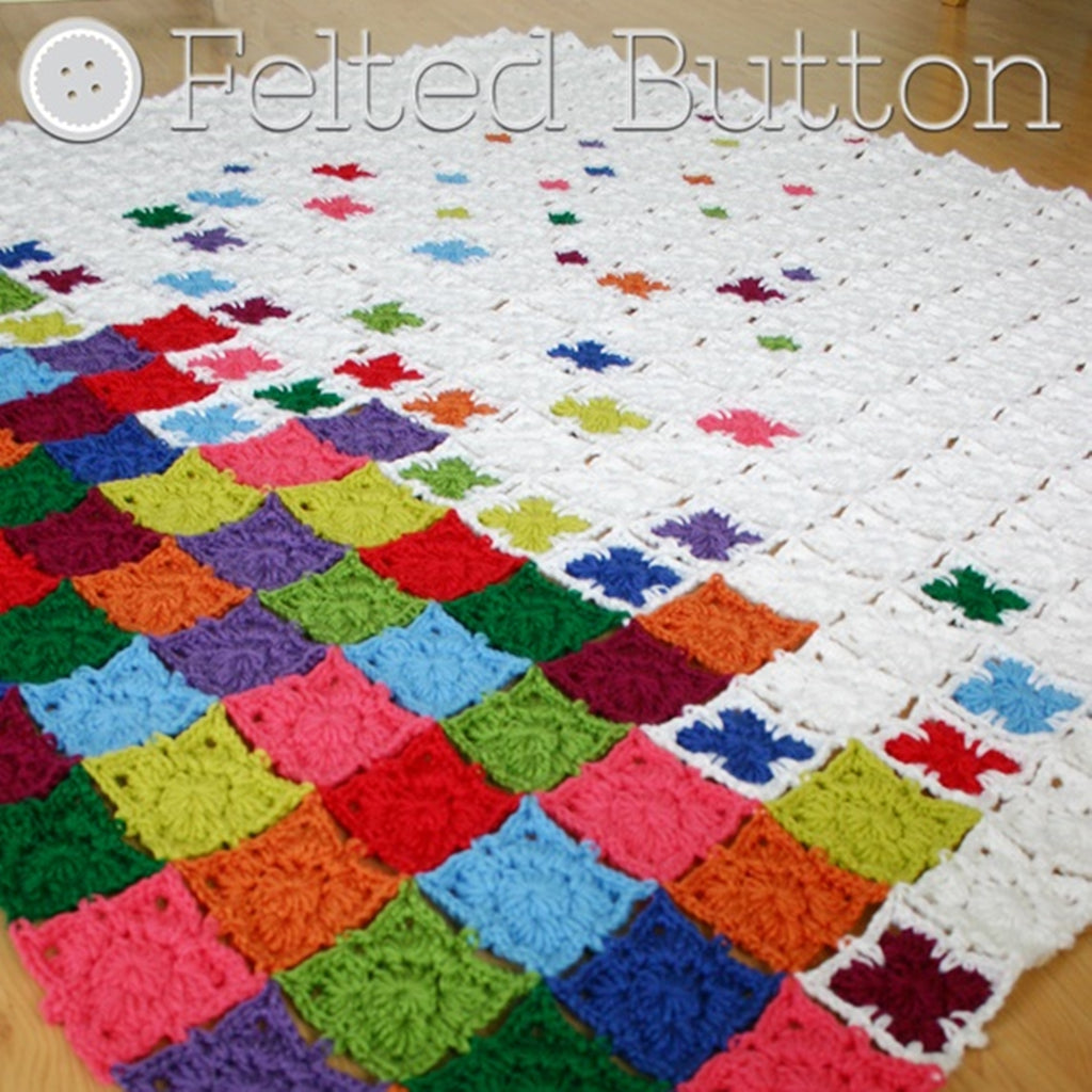 Modern graphic granny square blanket with rainbow colors in pile at bottom, Rainbow Sprinkles Blanket crochet throw pattern by Susan Carlson of Felted Button