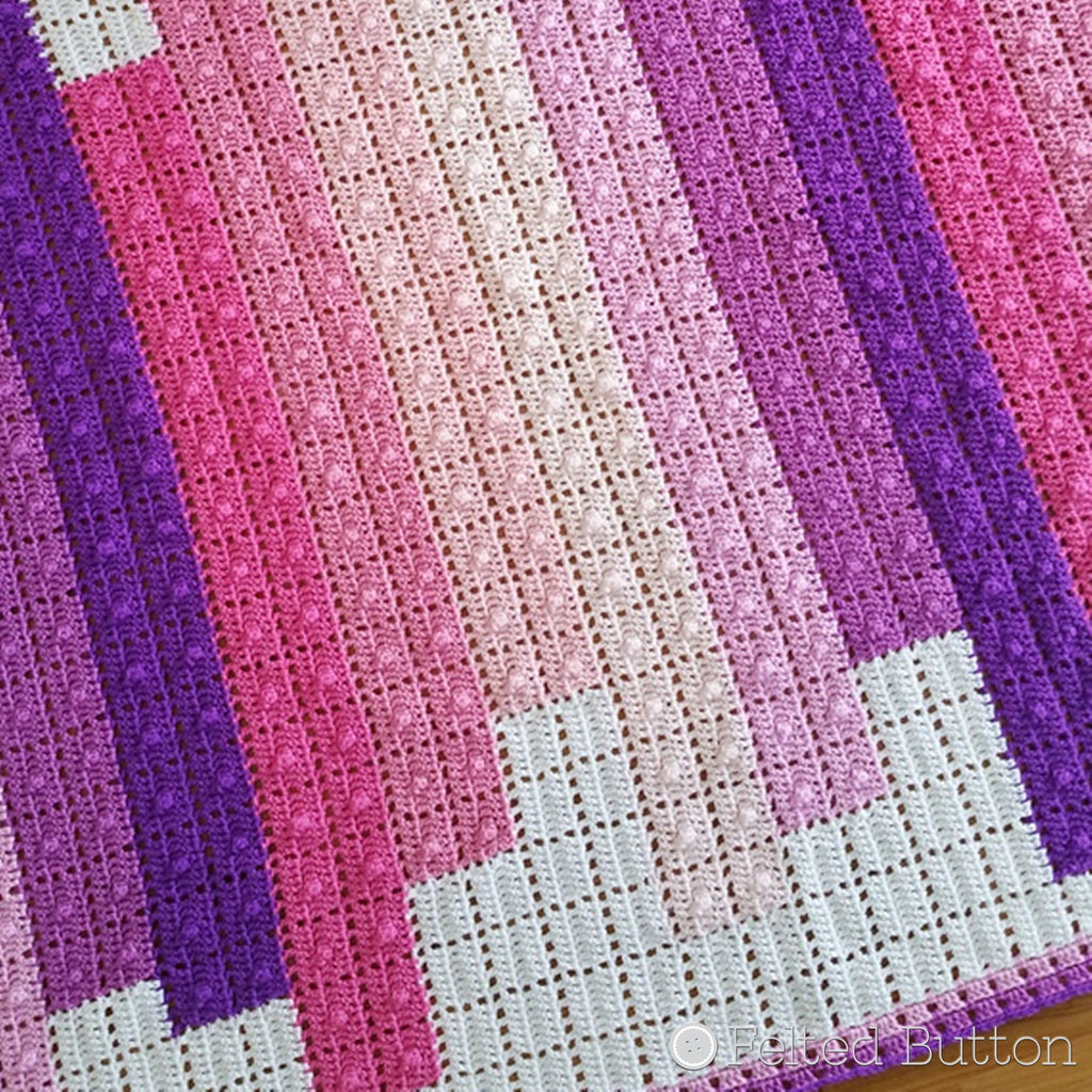Blocks of pink and purple stacked against white in crochet blanket, Teetering Tower Blanket crochet pattern by Susan Carlson of Felted Button