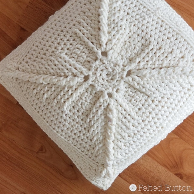 White textured crochet pillow cover on wood floor, free pattern using Asanas Square by Susan Carlson of Felted Button colorful crochet patterns 