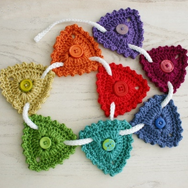 Button Bunting, rainbow triangles and buttons hanging from white cord, free crochet pattern by Susan Carlson of Felted Button | Colorful Crochet Patterns