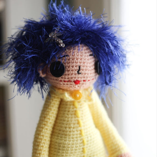 Coraline crochet doll with blue hair and yellow jacket, crochet designed by Susan Carlson of Felted Button | Colorful Crochet Patterns