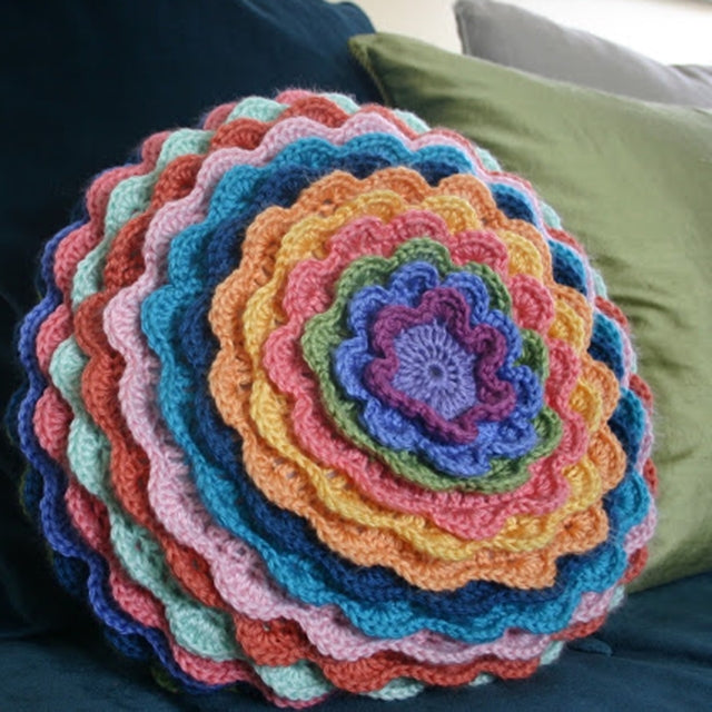 Flower pillow with layered scalloped edges on round cushion, by Susan Carlson of Felted Button | Colorful Crochet Patterns