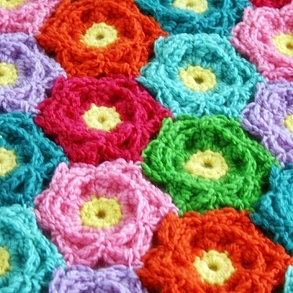 Highly textured crochet flowers in rainbow colors with yellow centers, Waikiki Wildflower Blanket crochet afghan or throw pattern by Susan Carlson of Felted Button | Colorful Crochet Patterns