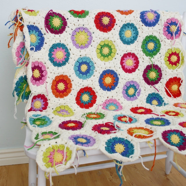 Colorful crochet blanket, hexagons with rainbow centers and white borders, unfinished wip by Susan Carlson of Felted Button | Colorful Crochet Patterns