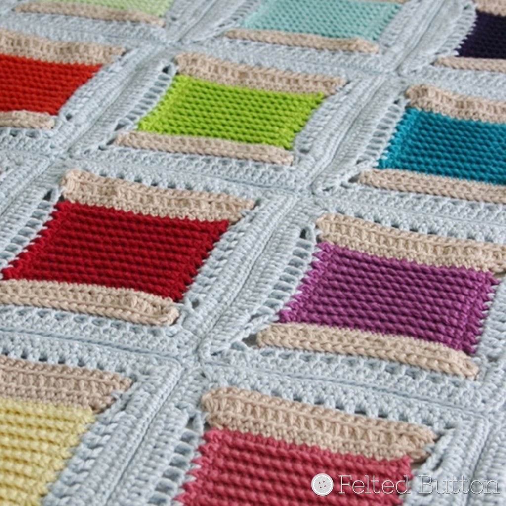 Pale blue crochet blanket with squares that resemble thimbles in a rainbow of colors, crochet pattern by Susan Carlson of Felted Button