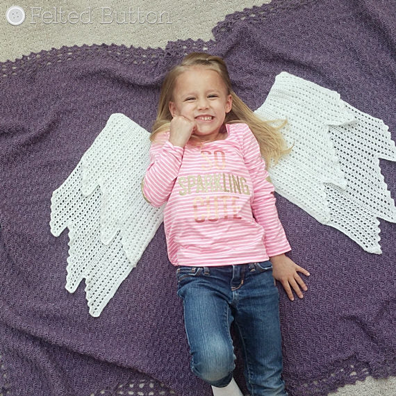 Little girl laying on purple blanket with angel wings, Embraced by Angels Blanket crochet pattern by Susan Carlson of Felted Button, colorful crochet patterns