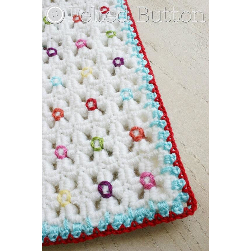 Wavy, textured crochet mat or blanket with colorful flower bud centers and red, turquoise border, designed by Susan Carlson of Felted Button